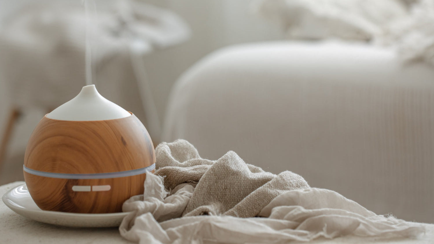 Wooden diffuser emitting steam on a light surface with a blurred background